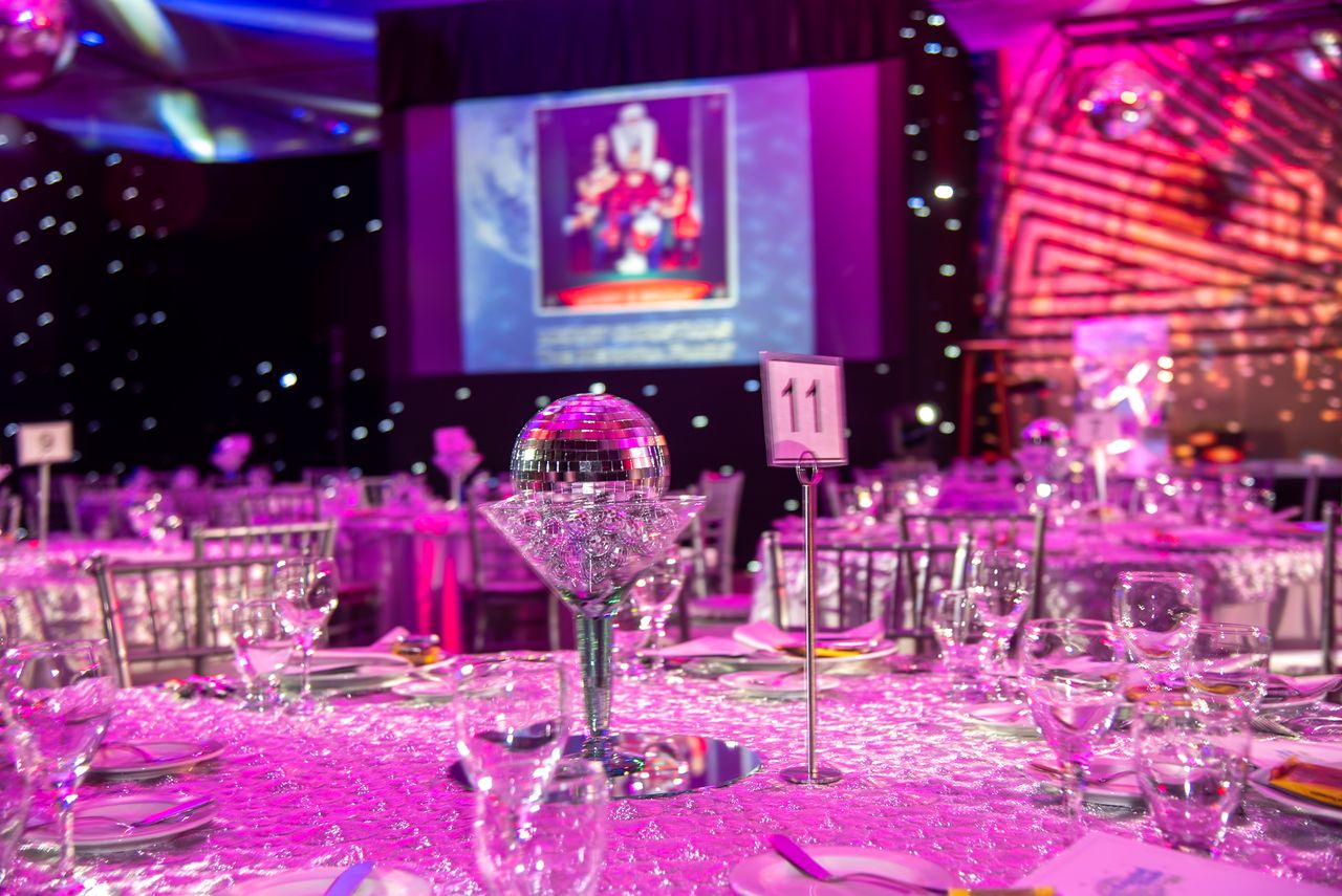 Mastering the First Impression: Your intriguing post title goes here Lavish themed dinner setup with disco balls and purple lighting for a glamorous event.